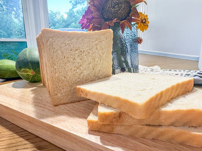 Fresh sliced homemade sandwich bread on a wooden cutting board